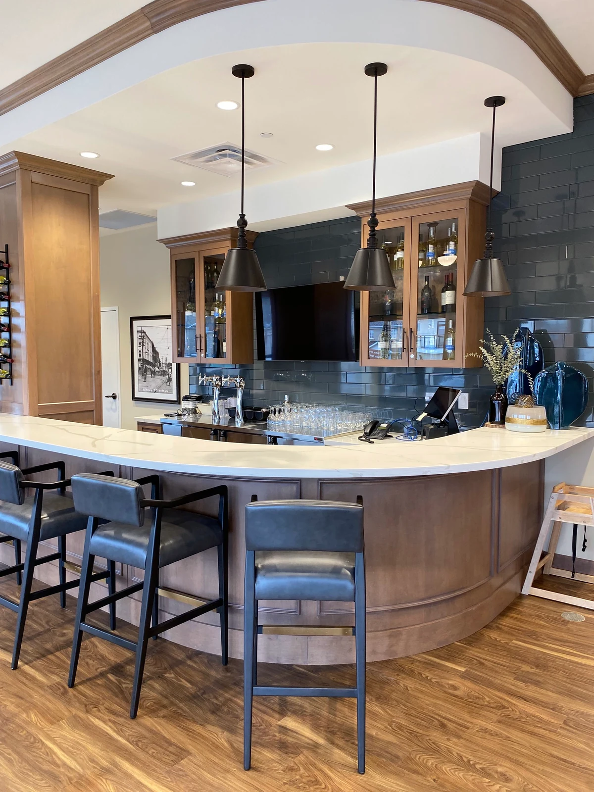 A curved panelled bar and glass-front cabinets at Amica Whitby