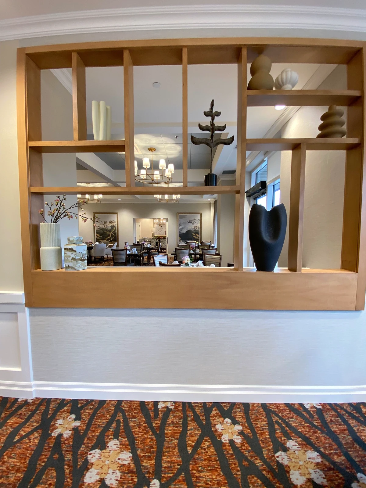 Open timber display screen framing a view into the dining room
